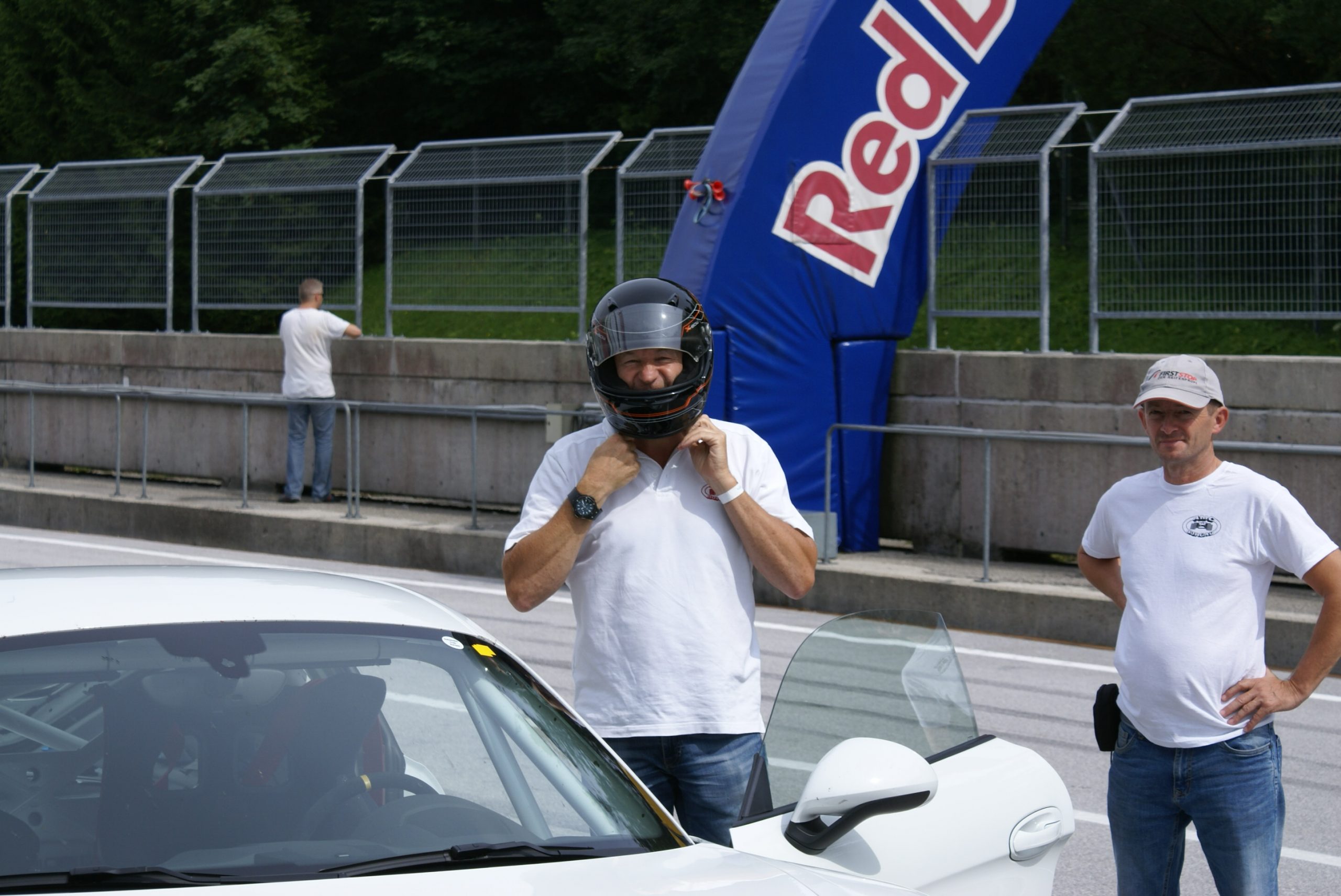 Fahrer setzt Helm neben Fahrzeug auf