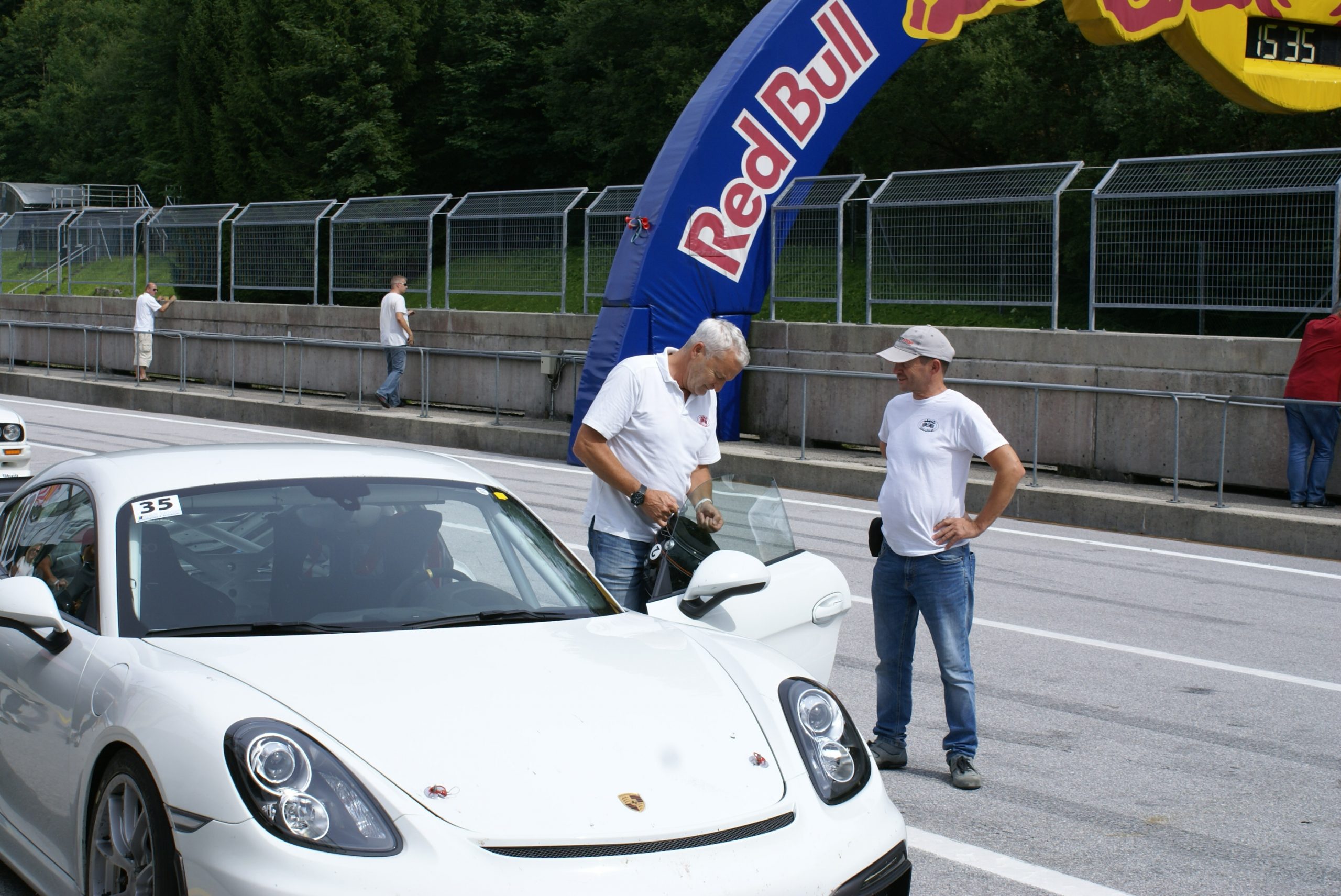 Porsche mit Personen in der Boxengasse